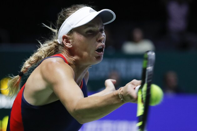 Caroline Wozniacki of Denmark plays a return shot while competing against Elina Svitolina of the Ukraine during their women's singles match at the WTA tennis finals in Singapore, Thursday, Oct. 25, 2018. (AP Photo/Vincent Thian)