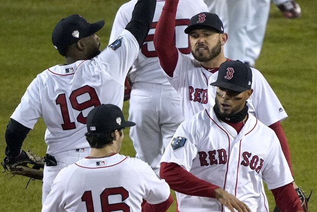Boston Red Sox's Andrew Benintendi (16), Xander Bogaerts, right front, Jackie Bradley Jr. (19) and Ian Kinsler, right rear, celebrate a 4-2 win over the Los Angeles Dodgers in Game 2 of the World Series baseball game Wednesday, Oct. 24, 2018, in Boston. (AP Photo/Elise Amendola)