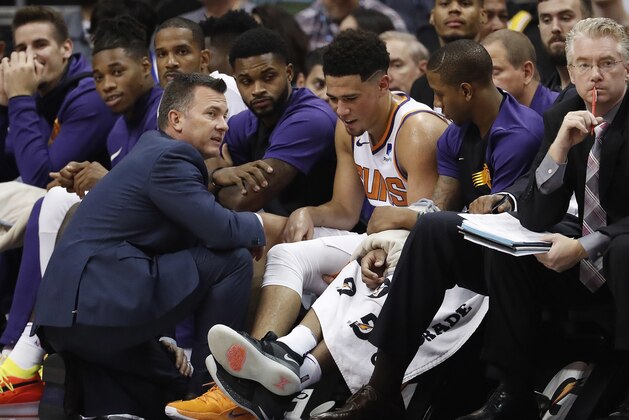 Phoenix Suns guard Devin Booker is assisted by a trainer after an injury during the second half of an NBA basketball game against the Los Angeles Lakers, Wednesday, Oct. 24, 2018, in Phoenix. (AP Photo/Matt York)