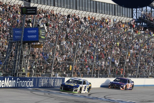 Chase Elliott (9) takes the checkered flag in front of Denny Hamlin (11) to win a NASCAR Cup Series auto race, Sunday, Oct. 7, 2018, at Dover International Speedway in Dover, Del. (AP Photo/Nick Wass)