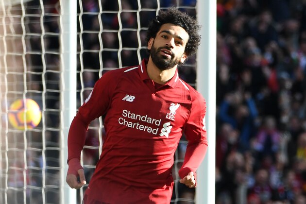 Liverpool's Egyptian midfielder Mohamed Salah celebrates scoring the opening goal during the English Premier League football match between Liverpool and Cardiff City at Anfield in Liverpool, north west England on October 27, 2018. (Photo by Paul ELLIS / AFP) / RESTRICTED TO EDITORIAL USE. No use with unauthorized audio, video, data, fixture lists, club/league logos or 'live' services. Online in-match use limited to 120 images. An additional 40 images may be used in extra time. No video emulation. Social media in-match use limited to 120 images. An additional 40 images may be used in extra time. No use in betting publications, games or single club/league/player publications. /         (Photo credit should read PAUL ELLIS/AFP/Getty Images)