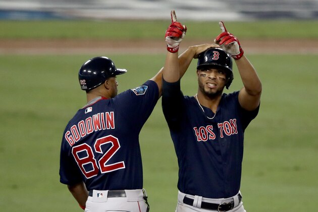 LOS ANGELES, CA - OCTOBER 27: First base coach Tom Goodwin #82 of the Boston Red Sox congratulates Xander Bogaerts #2 on his rbi single in the ninth inning against the Los Angeles Dodgers of Game Four of the 2018 World Series at Dodger Stadium on October 27, 2018 in Los Angeles, California. The Red Sox defeated the Dodgers 9-6. (Photo by Ezra Shaw/Getty Images)