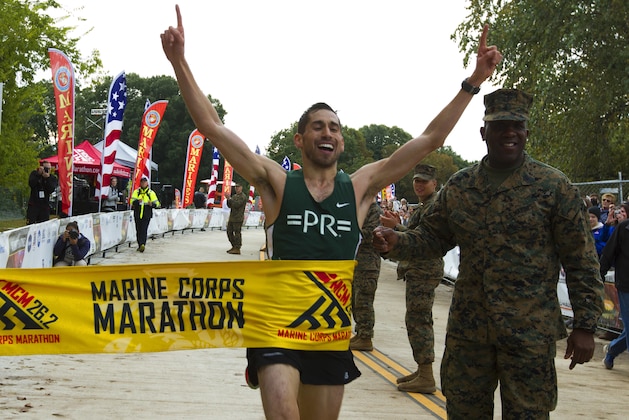 Jeffrey Stein rises his arms as he finish in the first place men's the 43rd Marine Corps Marathon, Sunday, Oct. 28, 2018, in Arlington, Va. (AP Photo/Jose Luis Magana