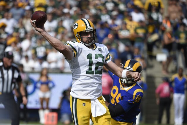 Green Bay Packers quarterback Aaron Rodgers (12) throws a pass under pressure from Los Angeles Rams defensive tackle Aaron Donald (99) during the first half of an NFL football game, Sunday, Oct. 28, 2018, in Los Angeles. (AP Photo/Denis Poroy)