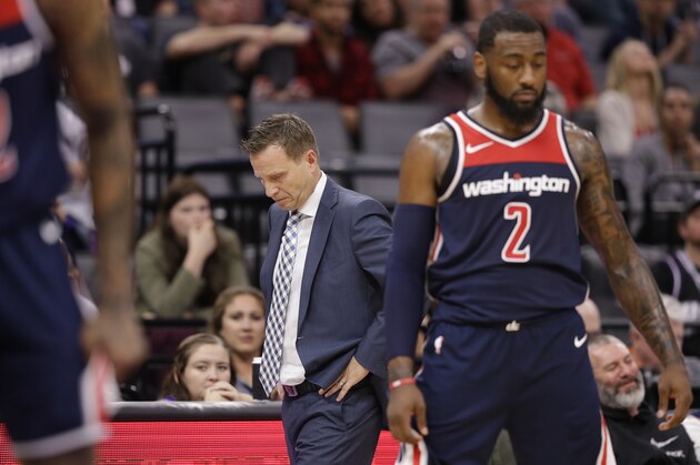 Washington Wizards head coach Scott Brooks, center, walks the sideline during the closing moments of the Wizards 116-112 loss to the Sacramento Kings in a NBA basketball game, Friday, Oct. 26, 2018, in Sacramento, Calif. At right is Wizards guard John Wall. (AP Photo/Rich Pedroncelli)