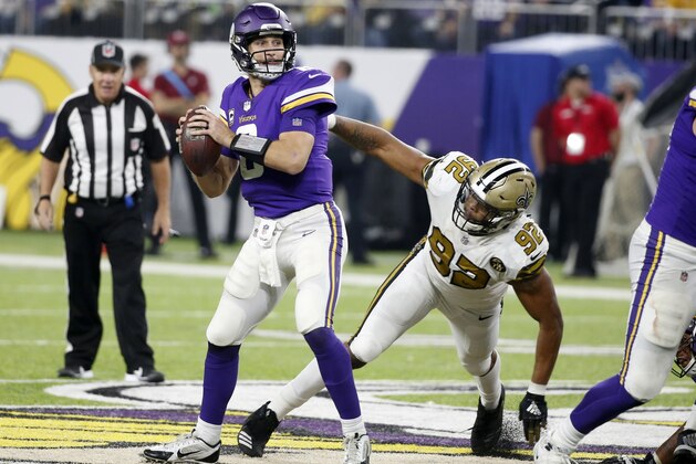 Minnesota Vikings quarterback Kirk Cousins, left, throws a pass in front of New Orleans Saints defensive end Marcus Davenport (92) during the second half of an NFL football game, Sunday, Oct. 28, 2018, in Minneapolis. (AP Photo/Bruce Kluckhohn)
