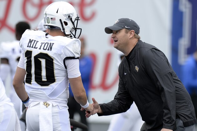 Central Florida head coach Josh Heupel shakes hands with quarterback McKenzie Milton (10) during warm ups before an NCAA college football game against Memphis Saturday, Oct. 13, 2018, in Memphis, Tenn. (AP Photo/Mark Zaleski)