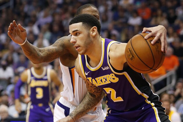 Los Angeles Lakers guard Lonzo Ball (2) drives around Phoenix Suns guard Isaiah Canaan during the first half of an NBA basketball game, Wednesday, Oct. 24, 2018, in Phoenix. (AP Photo/Matt York)