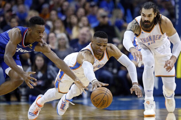 Oklahoma City Thunder guard Russell Westbrook, center, dives for a ball between Los Angeles Clippers guard Shai Gilgeous-Alexander, left, and center Steven Adams in the second half of an NBA basketball game in Oklahoma City, Tuesday, Oct. 30, 2018. (AP Photo/Sue Ogrocki)