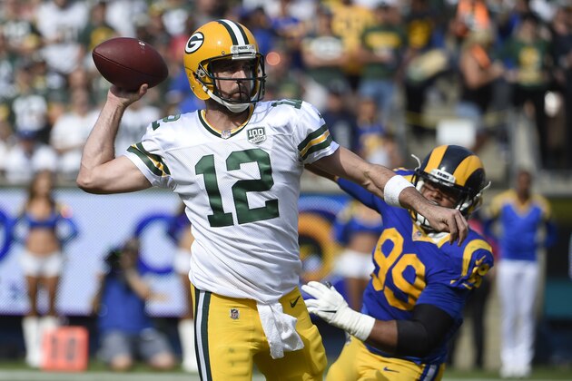Green Bay Packers quarterback Aaron Rodgers (12) throws a pass under pressure from Los Angeles Rams defensive tackle Aaron Donald (99) during the first half of an NFL football game, Sunday, Oct. 28, 2018, in Los Angeles. (AP Photo/Denis Poroy)