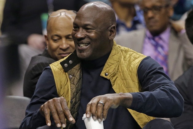 Charlotte Hornets owner Michael Jordan smiles as he watches the action in the first half of an NBA basketball game between the Charlotte Hornets and the Indiana Pacers in Charlotte, N.C., Monday, March 6, 2017. (AP Photo/Chuck Burton)