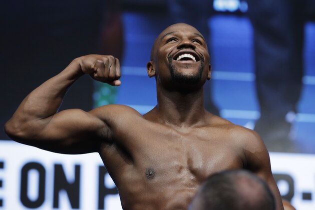 Floyd Mayweather Jr. poses on the scale during a weigh-in Friday, Aug. 25, 2017, in Las Vegas. Mayweather is scheduled to fight Conor McGregor in a boxing bout Saturday. (AP Photo/John Locher)