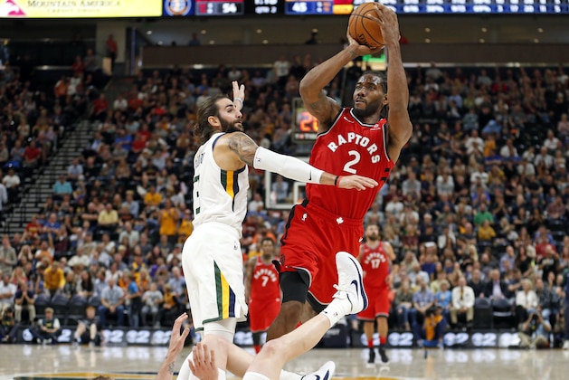 Toronto Raptors forward Kawhi Leonard (2) shoots as Utah Jazz's Joe Ingles, bottom, falls and Ricky Rubio (3) defends in the first half of an NBA preseason basketball game Tuesday, Oct. 2, 2018, in Salt Lake City. (AP Photo/Rick Bowmer)