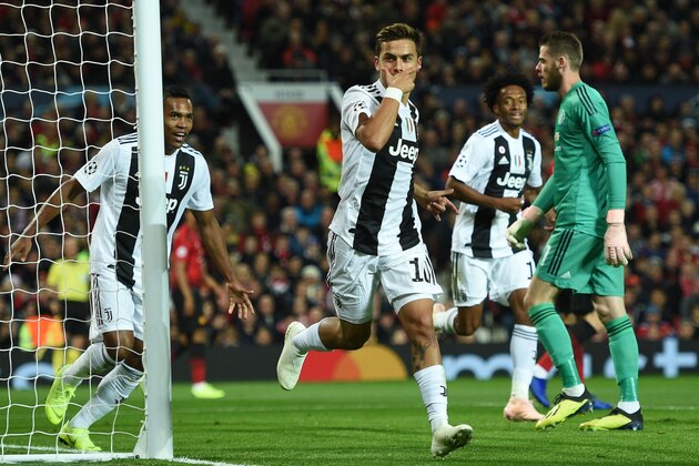 Juventus' Argentinian striker Paulo Dybala (C) celebrates after scoring the opening goal of the Champions League group H football match between Manchester United and Juventus at Old Trafford in Manchester, north west England, on October 23, 2018. (Photo by Oli SCARFF / AFP)        (Photo credit should read OLI SCARFF/AFP/Getty Images)