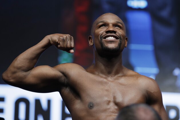 Floyd Mayweather Jr. poses on the scale during a weigh-in Friday, Aug. 25, 2017, in Las Vegas for his Saturday boxing bout against Conor McGregor. (AP Photo/John Locher)