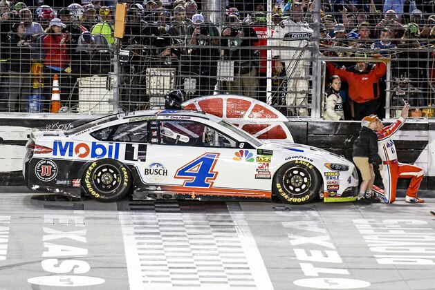 Kevin Harvick takes a photo with a young fan after winning a NASCAR Cup auto race at Texas Motor Speedway, Sunday, Nov. 4, 2018, in Fort Worth, Texas. (AP Photo/Larry Papke)