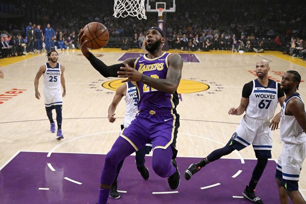 Los Angeles Lakers forward LeBron James, center, goes up for a shot as Minnesota Timberwolves guard Derrick Rose, left, forward Taj Gibson, second from right, and forward Andrew Wiggins watch during the first half of an NBA basketball game Wednesday, Nov. 7, 2018, in Los Angeles. (AP Photo/Mark J. Terrill)