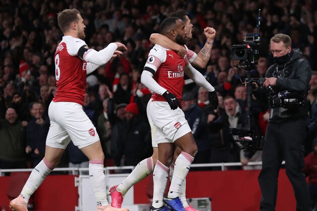 Arsenal's French striker Alexandre Lacazette (C) celebrates with teammates after scoring his team's first goal during the English Premier League football match between Arsenal and Liverpool at the Emirates Stadium in London on November 3, 2018. (Photo by Daniel LEAL-OLIVAS / AFP) / RESTRICTED TO EDITORIAL USE. No use with unauthorized audio, video, data, fixture lists, club/league logos or 'live' services. Online in-match use limited to 120 images. An additional 40 images may be used in extra time. No video emulation. Social media in-match use limited to 120 images. An additional 40 images may be used in extra time. No use in betting publications, games or single club/league/player publications. /         (Photo credit should read DANIEL LEAL-OLIVAS/AFP/Getty Images)
