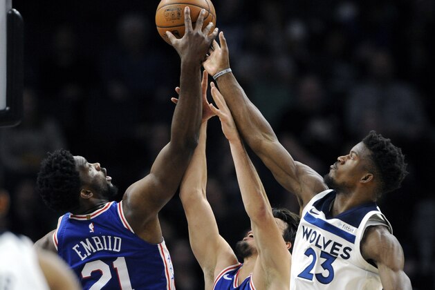 Philadelphia 76ers' Joel Embiid (21), of Cameroon, and Dario Saric (9), of Croatia, go for rebound against Minnesota Timberwolves guard Jimmy Butler (23) during the second quarter of an NBA basketball game on Tuesday, Dec. 12, 2017, in Minneapolis. (AP Photo/Hannah Foslien)