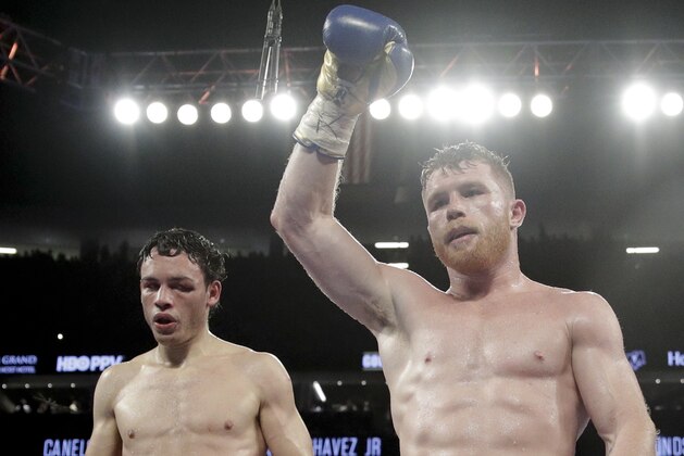 Canelo Alvarez, right, of Mexico, celebrates his win against Julio Cesar Chavez Jr., of Mexico, during their catch weight boxing match Saturday, May 6, 2017, in Las Vegas. (AP Photo/John Locher)