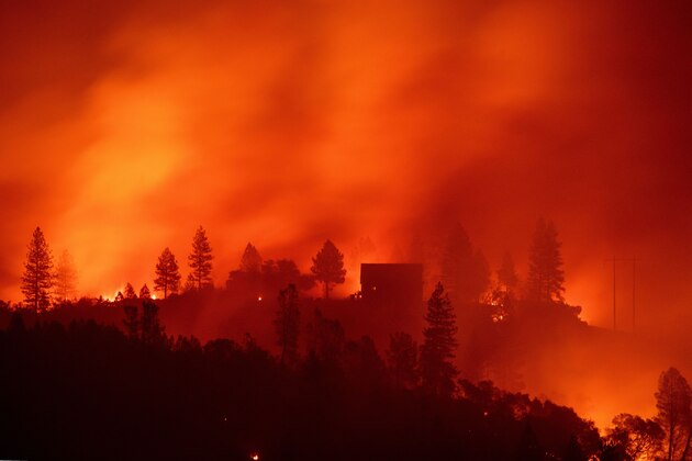 TOPSHOT - Flames from the Camp fire burn near a home atop a ridge near Big Bend, California, on November 10, 2018. - The death toll from the most destructive fire to hit California rose to 23 on November 10 as rescue workers recovered more bodies of people killed by the devastating blaze. Ten of the bodies were found in the town of Paradise while four were discovered in the Concow area, both in Butte County. (Photo by Josh Edelson / AFP)        (Photo credit should read JOSH EDELSON/AFP/Getty Images)