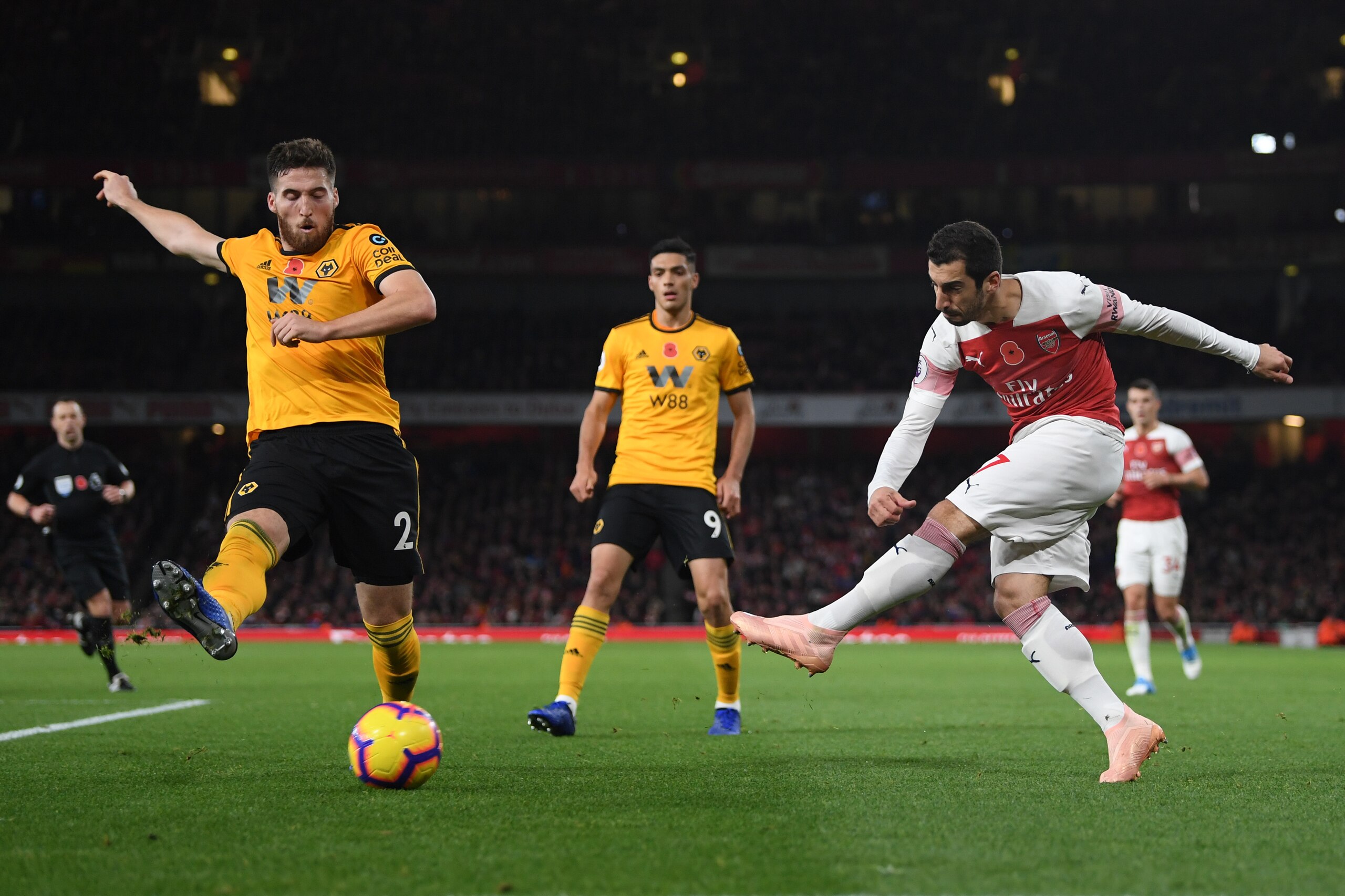 LONDON, ENGLAND - NOVEMBER 11:  Henrikh Mkhitaryan of Arsenal passes the ball under pressure from Matt Doherty of Wolverhampton Wanderers during the Premier League match between Arsenal FC and Wolverhampton Wanderers at Emirates Stadium on November 11, 2018 in London, United Kingdom.  (Photo by Shaun Botterill/Getty Images)