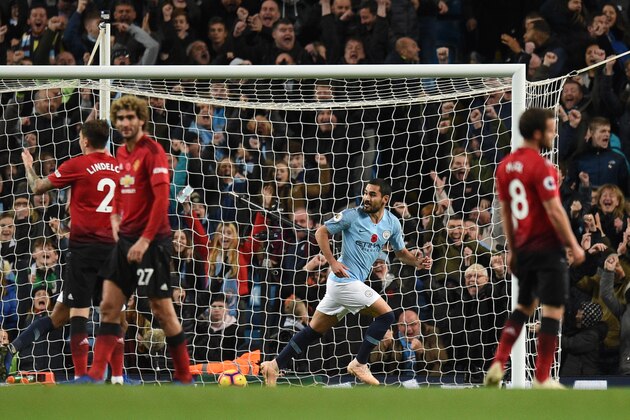 Manchester City's German midfielder Ilkay Gundogan (C) celebrates after scoring their third goal during the English Premier League football match between Manchester City and Manchester United at the Etihad Stadium in Manchester, north west England, on November 11, 2018. (Photo by Oli SCARFF / AFP) / RESTRICTED TO EDITORIAL USE. No use with unauthorized audio, video, data, fixture lists, club/league logos or 'live' services. Online in-match use limited to 120 images. An additional 40 images may be used in extra time. No video emulation. Social media in-match use limited to 120 images. An additional 40 images may be used in extra time. No use in betting publications, games or single club/league/player publications. /         (Photo credit should read OLI SCARFF/AFP/Getty Images)