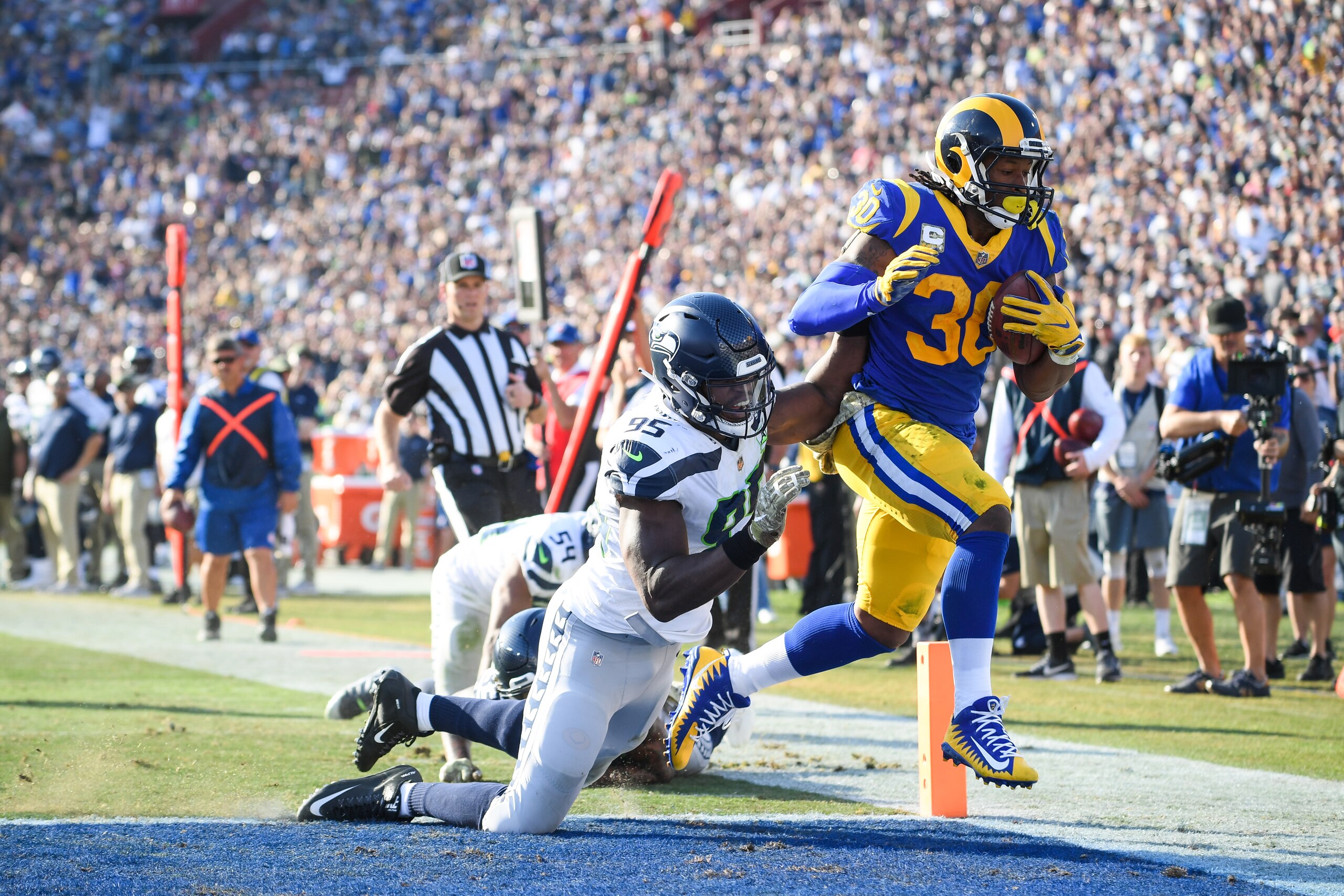 LOS ANGELES, CA - NOVEMBER 11: Running back Todd Gurley #30 of the Los Angeles Rams scores a touchdown in front of defensive end Dion Jordan #95 of the Seattle Seahawks to take a 17-14 lead in the second quarter at Los Angeles Memorial Coliseum on November 11, 2018 in Los Angeles, California. (Photo by Harry How/Getty Images) LOS ANGELES, CA - NOVEMBER 11: Running back Todd Gurley #30 of the Los Angeles Rams scores a touchdown in front of defensive end Dion Jordan #95 of the Seattle Seahawks to take a 17-14 lead in the second quarter at Los Angeles Memorial Coliseum on November 11, 2018 in Los Angeles, California. (Photo by Harry How/Getty Images)