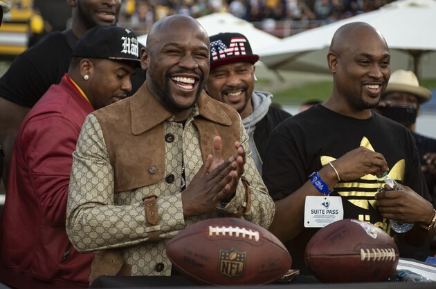 Boxing great Floyd Mayweather Jr., center, smiles after getting two touchdown balls during the second half of an NFL football game between the Seattle Seahawks and the Los Angeles Rams Sunday, Nov. 11, 2018, in Los Angeles. (AP Photo/Kyusung Gong)
