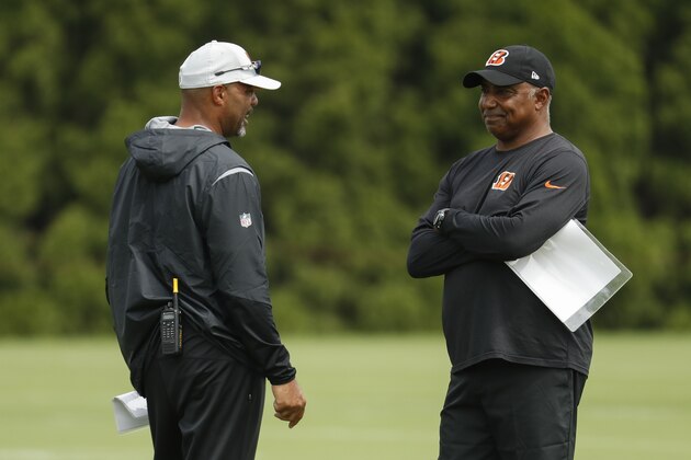 Cincinnati Bengals defensive coordinator Teryl Austin, left, and head coach Marvin Lewis, right, meet on the field during NFL football practice, Monday, July 30, 2018, in Cincinnati. (AP Photo/John Minchillo)