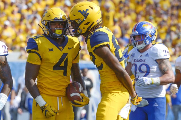 West Virginia Mountaineers wide receiver Dominique Maiden (82) talks with West Virginia Mountaineers running back Leddie Brown (4) during the second half of an NCAA college football game between the West Virginia Mountaineers and University of Kansas Jayhawks in Morgantown, W. Va., Saturday Oct. 6, 2018. The Mountaineers defeated the Jayhawks with a final score of 38-22. (AP Photo/Craig Hudson)