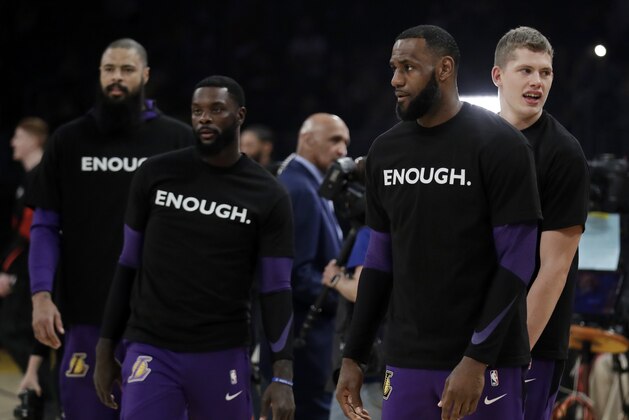 Member of the Los Angeles Lakers, from left, Tyson Chandler, Lance Stephenson, LeBron James and Moritz Wagner wear t-shirts with the word 'enough
