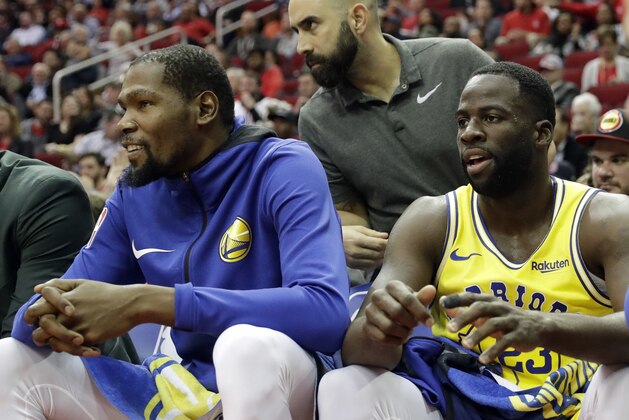 Golden State Warriors' Kevin Durant, left, and Draymond Green sit on the bench during the first half of an NBA basketball game against the Houston Rockets Thursday, Nov. 15, 2018, in Houston. (AP Photo/David J. Phillip)
