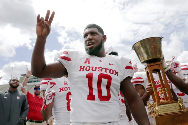 Houston Cougars defensive tackle Ed Oliver does the Cougar Paw with his teammates and the Bayou Bucket trophy after defeating Rice in a NCAA college football game Saturday, Sept. 1, 2018, in Houston. (AP Photo/Michael Wyke)