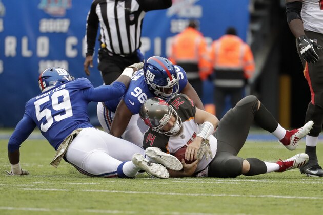 Tampa Bay Buccaneers quarterback Ryan Fitzpatrick, right, is sacked by New York Giants' Lorenzo Carter, left, and Kareem Martin during the first half of an NFL football game, Sunday, Nov. 18, 2018, in East Rutherford, N.J. (AP Photo/Julio Cortez)
