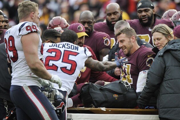 Houston Texans strong safety Kareem Jackson (25) reaches for Washington Redskins quarterback Alex Smith (11) as he leaves the field after an injury during the second half of an NFL football game, Sunday, Nov. 18, 2018 in Landover, Md. (AP Photo/Mark Tenally)