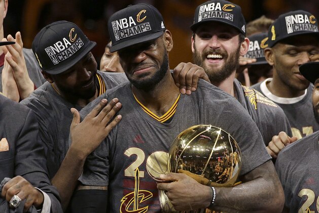 FILE - In this June 19, 2016, file photo, Cleveland Cavaliers forward LeBron James, center, celebrates with teammates, including Kevin Love, third from left, after Game 7 of basketball's NBA Finals against the Golden State Warriors in Oakland, Calif. James delivered on his personal pledge to bring home a title in June. And although it’s one he can never duplicate personally or for a fan base that had its heart broken and healed by him, the Cavaliers’ superstar and his teammates aren’t resting, getting comfortable or complacent. They want more. “We're still pretty much uptight,