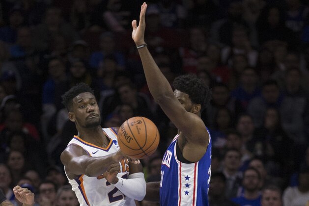 PHILADELPHIA, PA - NOVEMBER 19: Deandre Ayton #22 of the Phoenix Suns passes the ball against Joel Embiid #21 of the Philadelphia 76ers in the first quarter at the Wells Fargo Center on November 19, 2018 in Philadelphia, Pennsylvania. NOTE TO USER: User expressly acknowledges and agrees that, by downloading and or using this photograph, User is consenting to the terms and conditions of the Getty Images License Agreement. (Photo by Mitchell Leff/Getty Images)