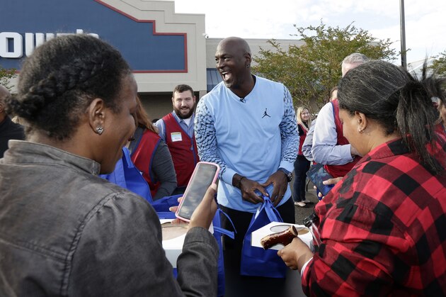 Charlotte Hornets owner Michael Jordan greets people and hands out food for Thanksgiving to members of the community in Wilmington, N.C., Tuesday, Nov. 20, 2018. (AP Photo/Gerry Broome)