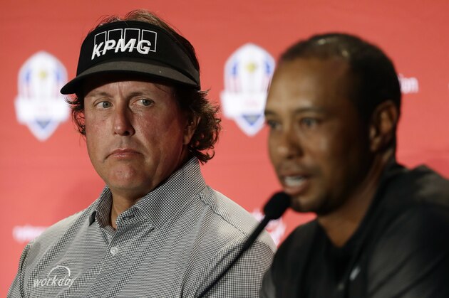 Phil Mickelson, left, listens to Tiger Woods speak during a news conference where they were announced as captain's picks for the 2018 U.S. Ryder Cup Team, Tuesday, Sept. 4, 2018, in West Conshohocken, Pa. (AP Photo/Matt Slocum)