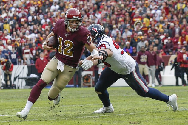 Washington Redskins quarterback Colt McCoy (12) scrambles past Houston Texans defensive end J.J. Watt (99) during the second half of an NFL football game, Sunday, Nov. 18, 2018 in Landover, Md. (AP Photo/Alex Brandon)