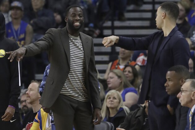 Golden State Warriors forward Draymond Green, left, and guard Stephen Curry gesture from the sideline during the first half of the team's NBA basketball game against the Oklahoma City Thunder in Oakland, Calif., Wednesday, Nov. 21, 2018. (AP Photo/Jeff Chiu)