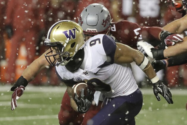 Washington running back Myles Gaskin (9), is tackled by Washington State linebacker Peyton Pelluer as he rushes during the first half of an NCAA college football game, Friday, Nov. 23, 2018, in Pullman, Wash. (AP Photo/Ted S. Warren)