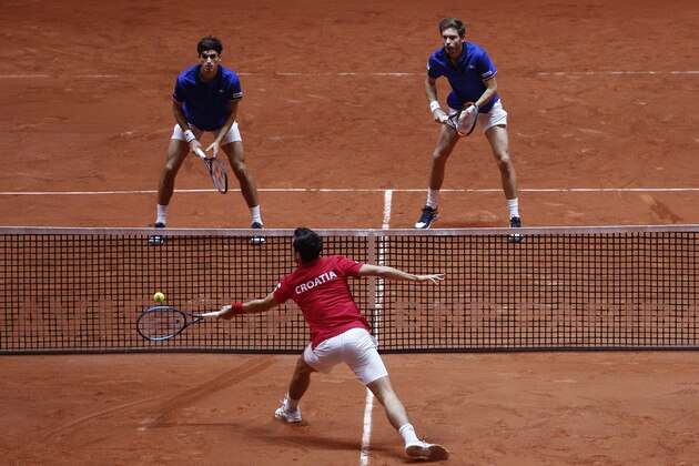 Mate Pavic of Croatia, bottom, returns the ball to France's Nicolas Mahut, right, and Pierre Hughes Herbert during the Davis Cup final between France and Croatia, Saturday, Nov. 24, 2018 in Lille, northern France. Croatia is within one point of a second Davis Cup title after Borna Coric and Marin Cilic dispatched their French rivals in the opening singles matches of the final to take a 2-0 lead. (AP Photo/Thibault Camus)