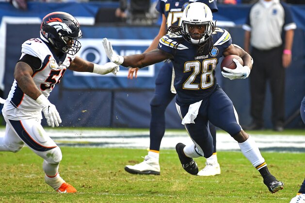 CARSON, CA - NOVEMBER 18: Melvin Gordon #28 of the Los Angeles Chargers gets past Todd Davis #51 of the Denver Broncos as he runs the ball in the game at StubHub Center on November 18, 2018 in Carson, California. (Photo by Jayne Kamin-Oncea/Getty Images)