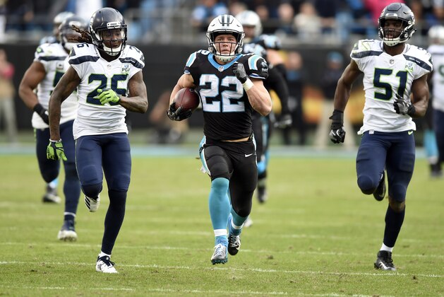 Carolina Panthers' Christian McCaffrey (22) runs for a long gain past Seattle Seahawks' Shaquill Griffin (26) and Barkevious Mingo (51) during the second half of an NFL football game in Charlotte, N.C., Sunday, Nov. 25, 2018. (AP Photo/Mike McCarn)