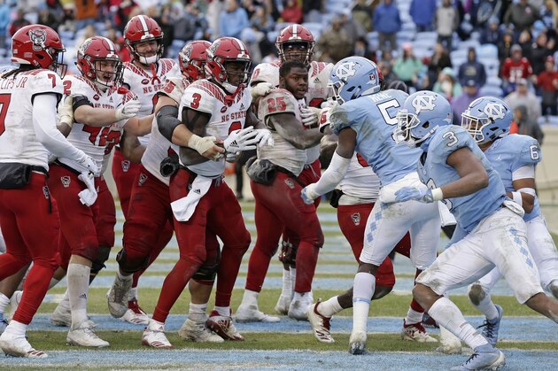 North Carolina State, left, and North Carolina players scuffle following the game-winning touchdown by North Carolina State's Reggie Gallaspy II (25) in overtime of an NCAA college football game in Chapel Hill, N.C., Saturday, Nov. 24, 2018. North Carolina State won 43-28. (AP Photo/Gerry Broome)