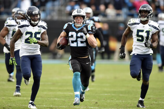 Carolina Panthers' Christian McCaffrey (22) runs for a long gain past Seattle Seahawks' Shaquill Griffin (26) and Barkevious Mingo (51) during the second half of an NFL football game in Charlotte, N.C., Sunday, Nov. 25, 2018. (AP Photo/Mike McCarn)
