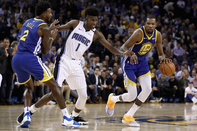 OAKLAND, CA - NOVEMBER 26:  Kevin Durant #35 of the Golden State Warriors dribbles around a pick set by Jordan Bell #2 of the Golden State Warriors while he is guarded by Jonathan Isaac #1 of the Orlando Magic at ORACLE Arena on November 26, 2018 in Oakland, California. NOTE TO USER: User expressly acknowledges and agrees that, by downloading and or using this photograph, User is consenting to the terms and conditions of the Getty Images License Agreement.  (Photo by Ezra Shaw/Getty Images)