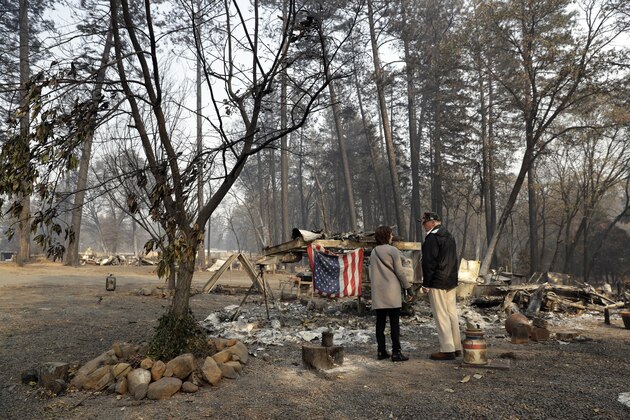 President Donald Trump talks to Mayor Jody Jones as he visits a neighborhood impacted by the wildfires, Saturday, Nov. 17, 2018, in Paradise, Calif. (AP Photo/Evan Vucci)